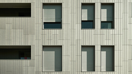 Ventanas en fachada gris de edificio moderno luz solar y sombras