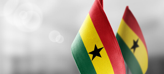 Small national flags of the Ghana on a light blurry background