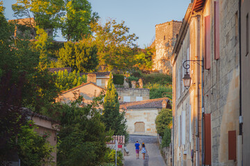 A tourist couple hold hands strolling through the charming French wine country old town village of Saint Emilion in Bordeaux, France.