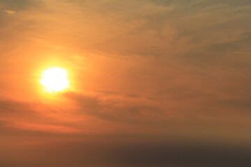 Fototapeta premium an artistic view of the beautiful orange sky with clouds and a bright yellow sun at a hot summer day in zeeland in the netherlands