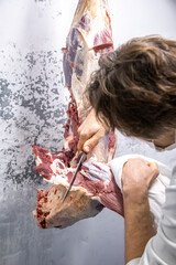 Male butcher cutting meat.