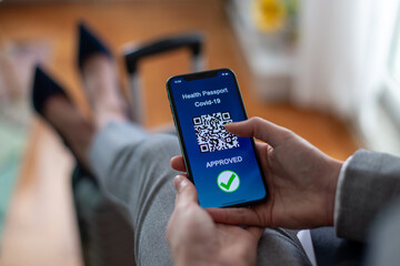 Vaccinated person using digital health passport app in mobile phone for travel during covid-19...
