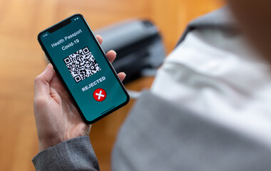 Vaccinated person using digital health passport app in mobile phone for travel during covid-19 pandemic. Rejected for travel.