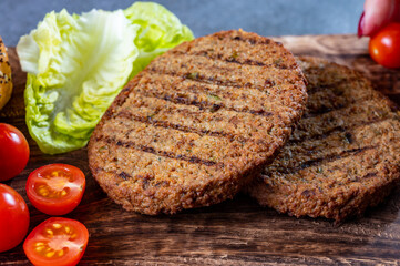Making tasty vegetarian hamburgers from plant based grilled burgers, fresh bakes buns and organic vegetables