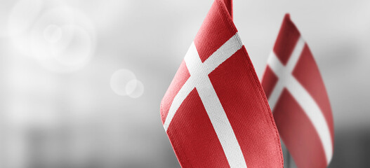 Small national flags of the Denmark on a light blurry background