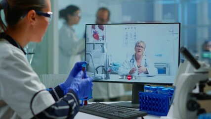 Physician doctor offering medical online advices to chemist student using pc. Scientist holding blood sample during online discussion, virtual conference, helping on telemedicine, healthcare support