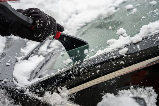 Ice Scraper Is Scraping A Car Windshield Free Of Ice And Snow