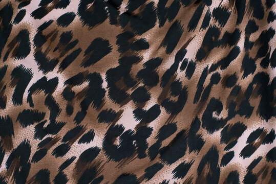 Fabric with a print of the skin of a cheetah, leopard, wild predators. A woman in clothes made of such fabric feels strong, bold and a little wild