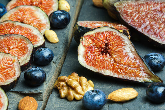 tabla de brevas, frutos secos y ar&aacute;ndanos sobre piedra laja 