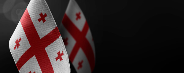 Small national flags of the Georgia on a dark background