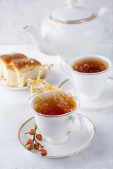 Splashing tea in a porcelain teacup on light background. English teatime