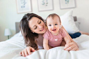 Fototapeta premium happy family. Mother and baby playing and smiling under a blanket