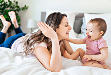happy family. Mother and baby playing and smiling under a blanket © Louis-Paul Photo