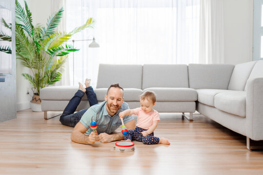 man playing with her baby in the living room