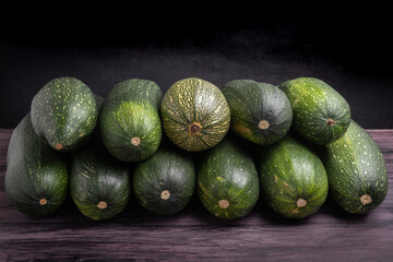 pile of zucchini on a dark wooden table