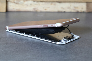 Smartphone défectueux : écran cassé et batterie gonflée sur un bureau