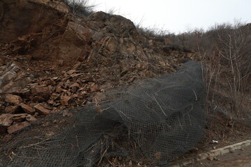 Elisseina, Bulgaria - February 2, 2021: Heavy chain and wheeled equipment clears the highway after a rock collapse near Elisseina station, Bulgaria