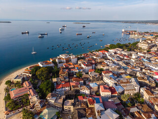 Zanzibar Aerial Shot of Stone Town Beach with Traditional Dhow Fisherman Boats in the Ocean at Sunset Time - obrazy, fototapety, plakaty