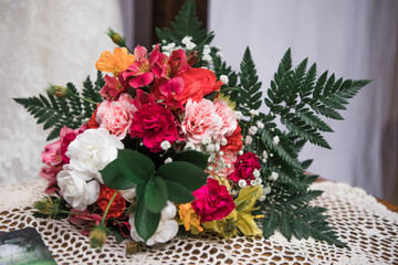 Pink, white, yellow, and orange flowers in a bouquet ; fresh with green leaves
