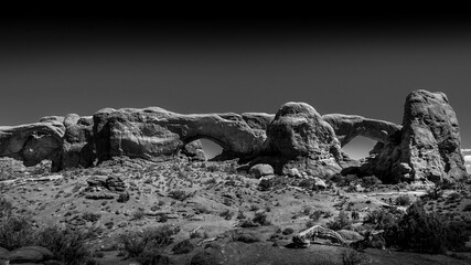 Fototapeta na wymiar Black and White Photo of the North and South Window Arches in the desert landscape of the Windows Section in Arches National Park, Utah, United States