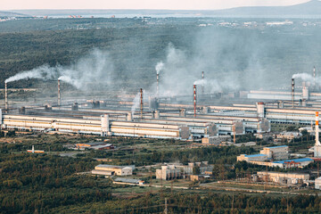 Aerial view of the factory. Environmental pollution. The pipes emit smoke into the atmosphere.