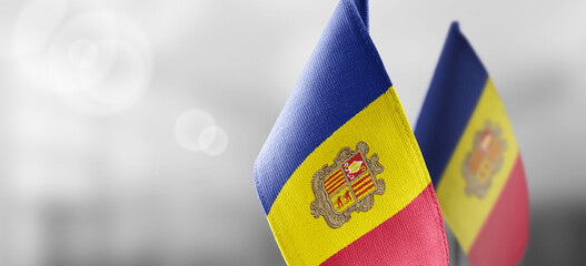 Small national flags of the Andorra on a light blurry background - obrazy, fototapety, plakaty