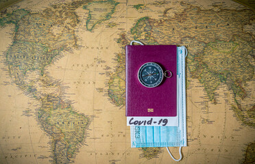 Passport with note COVID-19 and protective mask,on the world map,Coronavirus outbreak situation