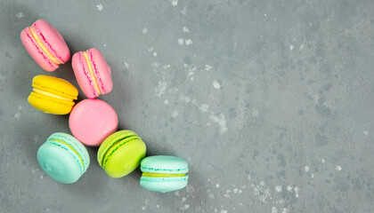 Bright pastries macarons on a gray background.