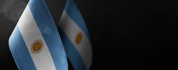 Small national flags of the Argentina on a dark background