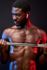 black sportsman pumping arm muscles biceps with weights, isolated on black background. workout and bodybuilding concept.