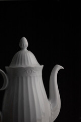classic white teapot in a black background