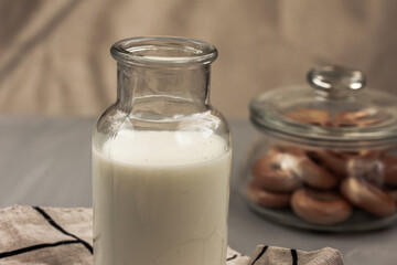 Milk in glass bottle and tasty bagels in glass jar. Side view