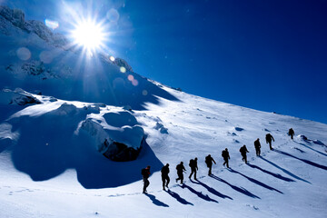 Summit hikes and adventures of professional mountaineering team in a cold winter day