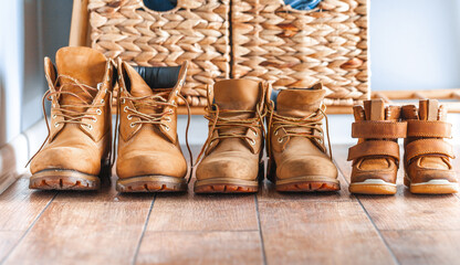 Happy home family concept. Small and big yellow boots together. Leather tourist boots. Shoes of...