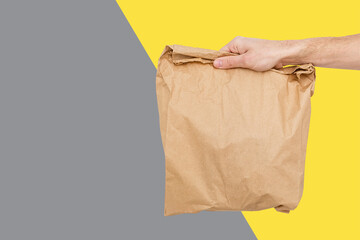 Close up female holds in hand brown clear empty blank craft paper bag for takeaway Delivery service...