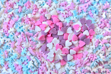 Delicious sugar candy unicorns in red, blue and white as sweet cake decoration and birthday topping with little horses and unicorn sprinkles show love for confection frosting of hearts
