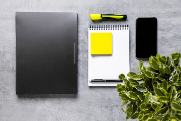 Laptop, phone, and office supplies on a gray concrete table. Remote work. Distance learning. uminous yellow and extremely gray. The color of 2021. Copy space