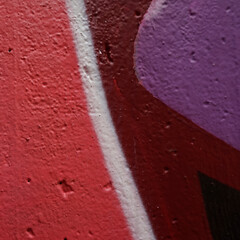 Detail of a sprayed wall. Colors: red, wine-red,  white, black and purple. Color on concrete. Background