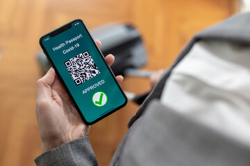 Vaccinated person using digital health passport app in mobile phone for travel during covid-19...