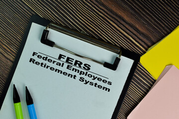 FERS - Federal Employees Retirement System write on a paperwork isolated on Wooden Table.