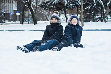 Fototapeta na wymiar boy walks and has fun in the snow in the city park. winter walk, winter fun