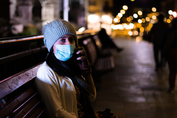 woman with mask, covid, calling on cell phone. Woman at night in the street, quarantined. pandemic. worried. person,