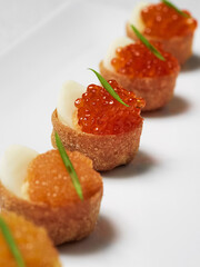 tartalett with red salmon caviar rolls isolated on white