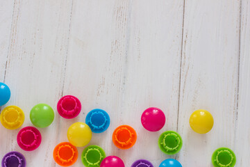 colorful mosaic on a wooden background. Children's toys on a white table.