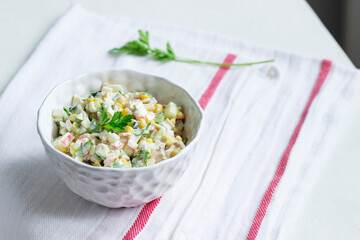 Vegetable salad with crab sticks, dressed with mayonnaise.
