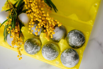 Happy Easter. Marble Eggs Mimosa on the Kitchen Table. Design and traditional decoration for the Holiday.