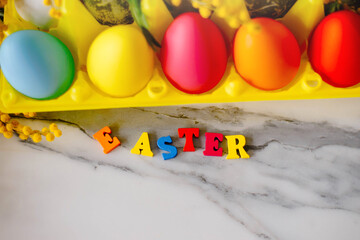 Fototapeta na wymiar Letters Easter Background Colored Eggs. Postcard. Family Tradition Concept. Selective focus.