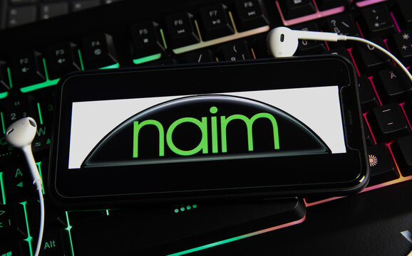Viersen, Germany - January 9. 2021: Closeup of smartphone screen with logo lettering online music audio streaming service naim on computer keyboard