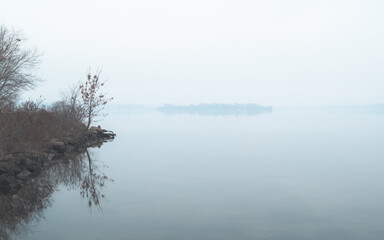 rocky river bank in fog