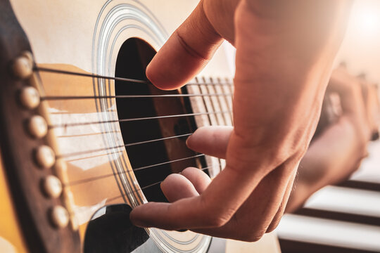 Close up a man's hands playing acoustic guitar. Playing acoustic guitar at a recording studio.